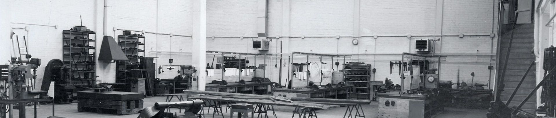 schwarz-weiße fotografie einer firmenhalle mit tischplatten aus holz