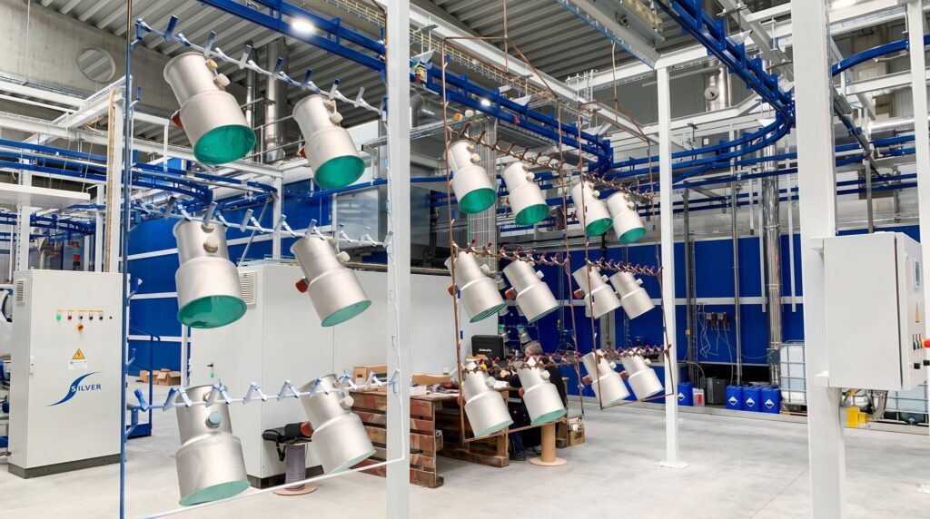 Aufgehängte Bauteile auf der Förderanlage der Pulverbeschichtung bei FUTRONIKA in Brunnthal
