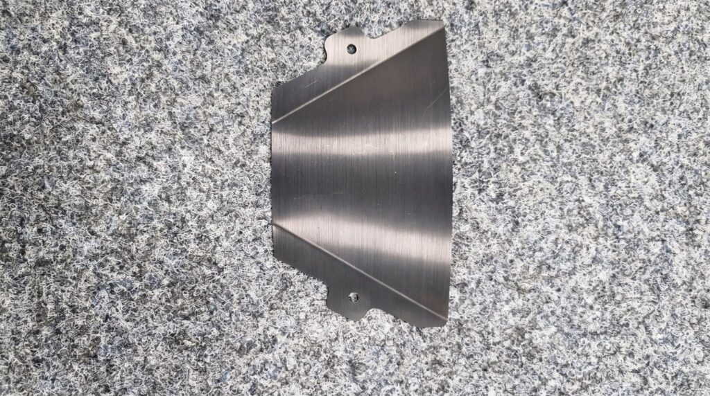 Eloxiertes Frästeil aus Aluminium auf der Granitplatte in der Qualitätssicherung der FUTRONIKA AG